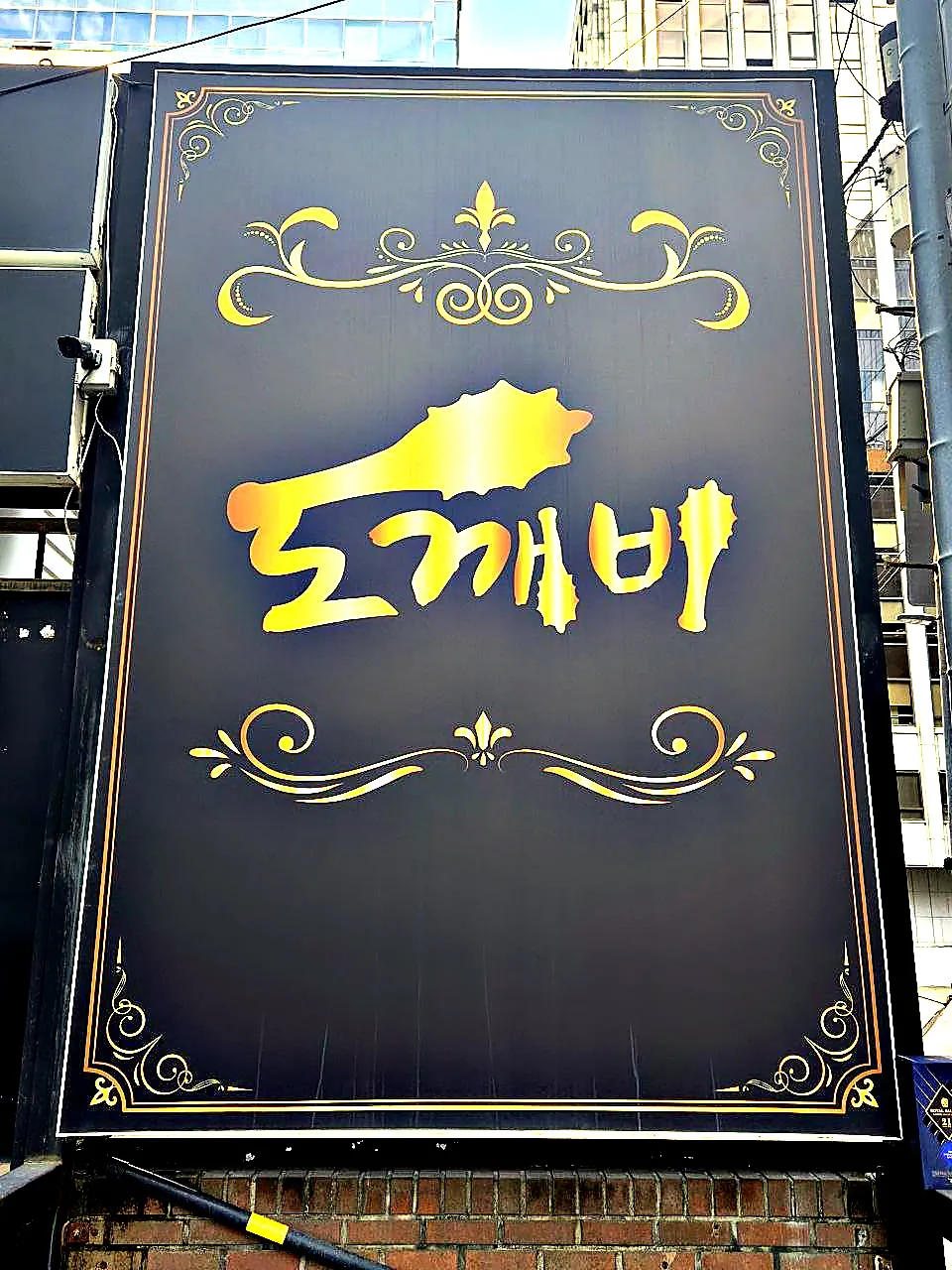 검은 바탕에 금색 장식과 함께 도깨비라고 쓴 강남 도깨비 대형 입간판 사진