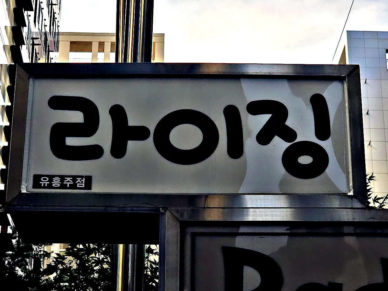 라이징이라고 쓴 강남 라이징 간판을 길에서 올려다본 사진