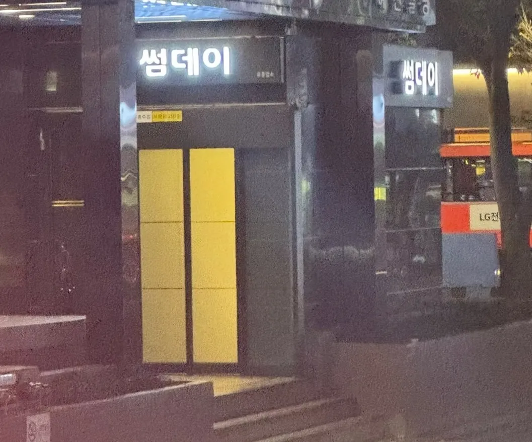 이전 상호 썸데이 간판이 켜진 건물 입구를 밤에 촬영한 사진