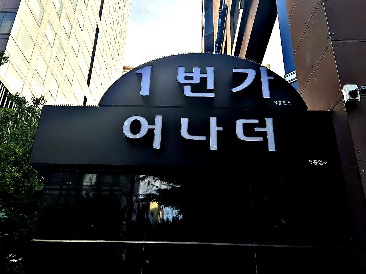 건물에 달린 강남 어나더(1번가 어나더) 간판을 길에서 올려다본 사진