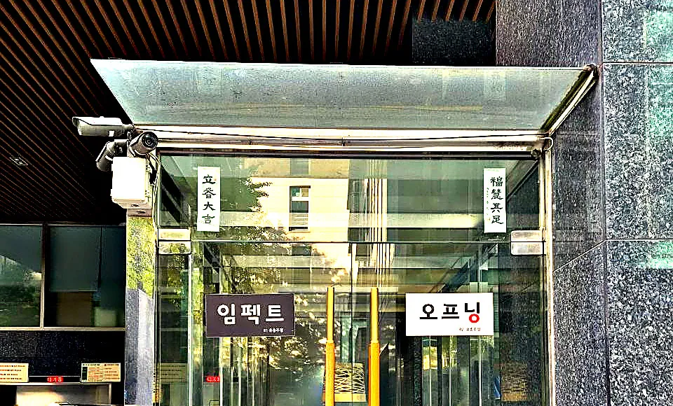 강남 임팩트 건물 입구. 유리 출입구 위에 임펙트와 오프닝 층별 안내판이 붙어 있다