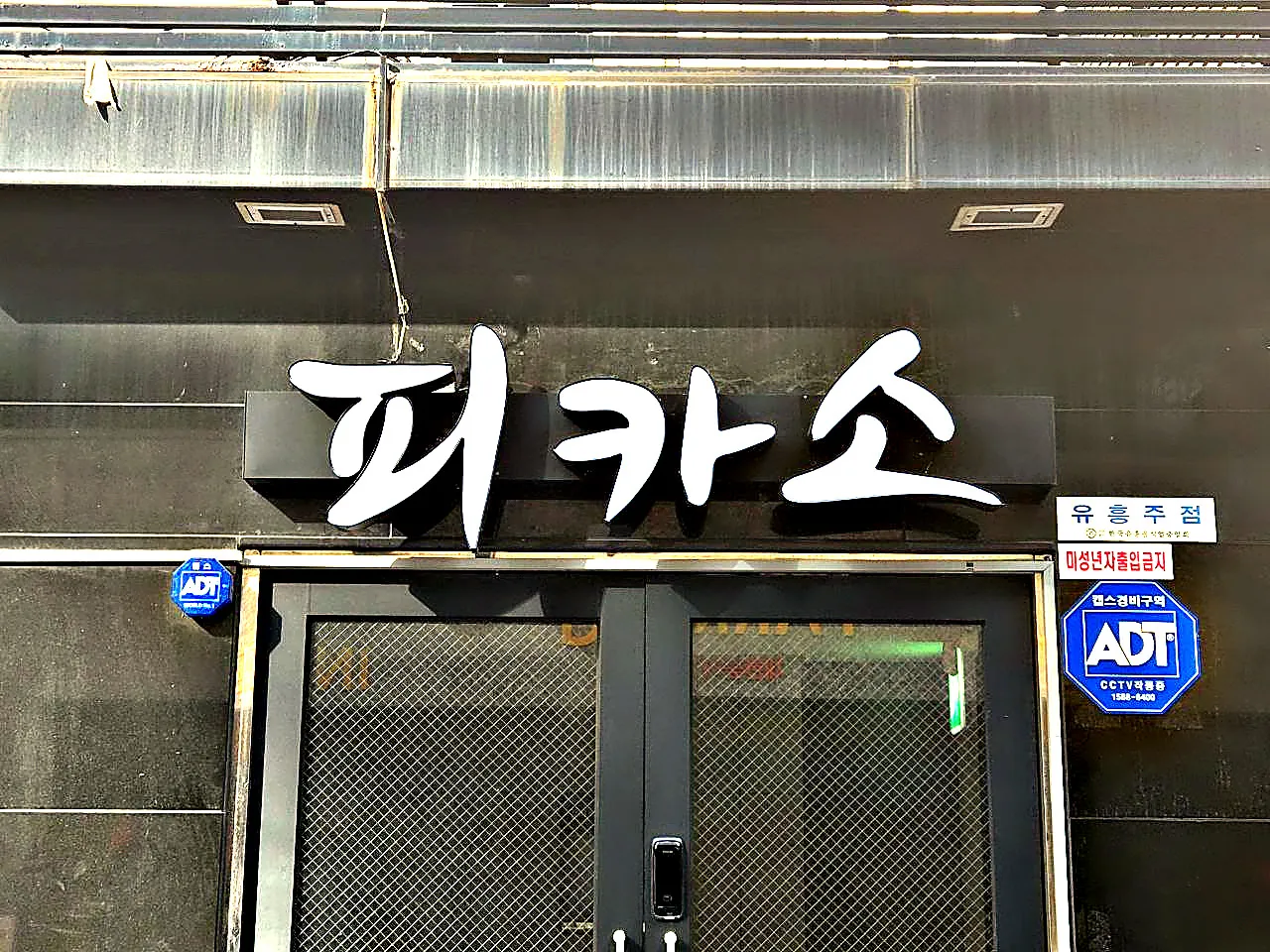 출입문 위에 달린 강남 피카소 입체 간판을 가까이 촬영한 사진