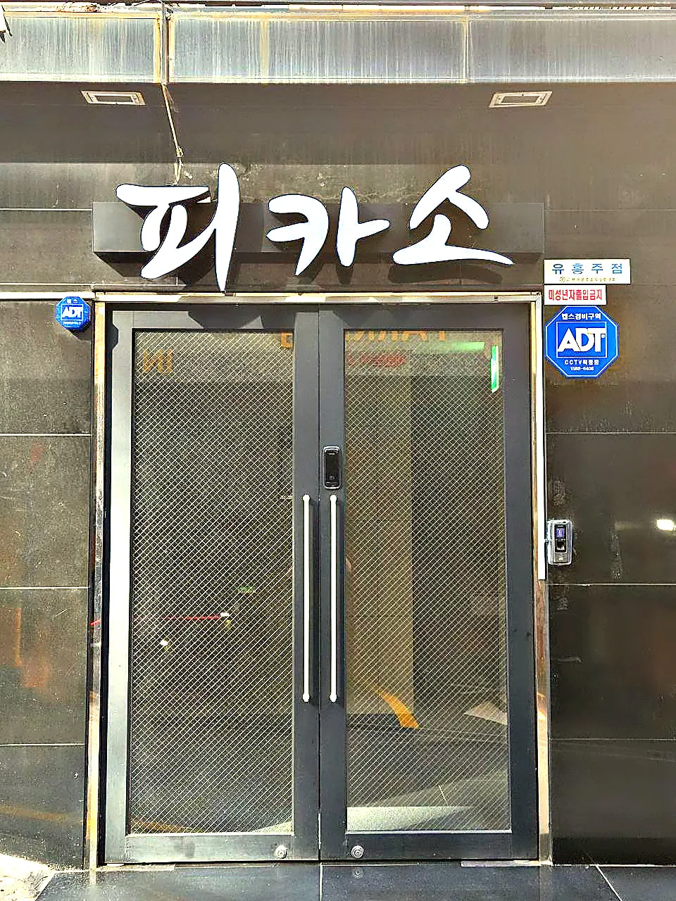 강남 피카소 간판과 격자무늬 유리 출입문을 바닥까지 정면에서 촬영한 사진